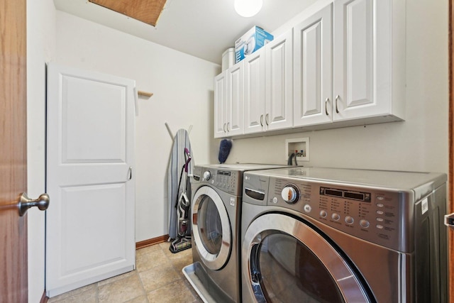 clothes washing area with washer and clothes dryer, cabinet space, and baseboards