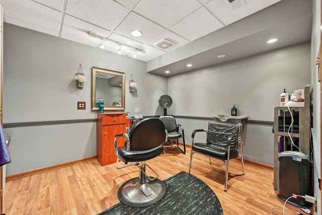 interior space featuring a paneled ceiling, visible vents, baseboards, light wood finished floors, and rail lighting