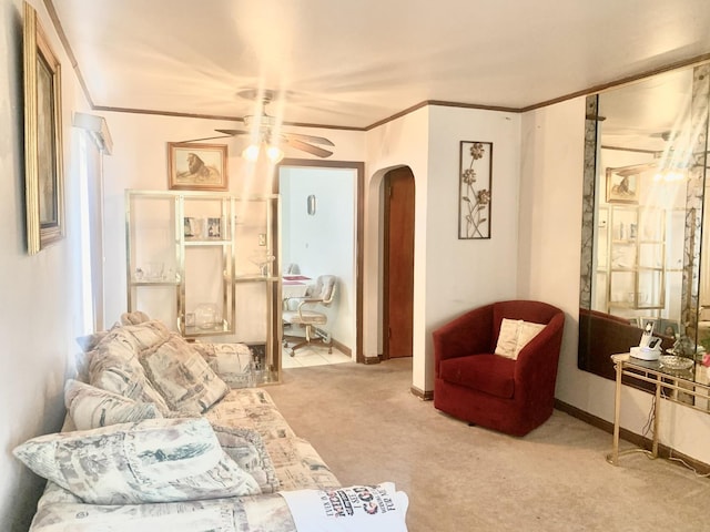 carpeted living room with a ceiling fan, baseboards, arched walkways, and crown molding