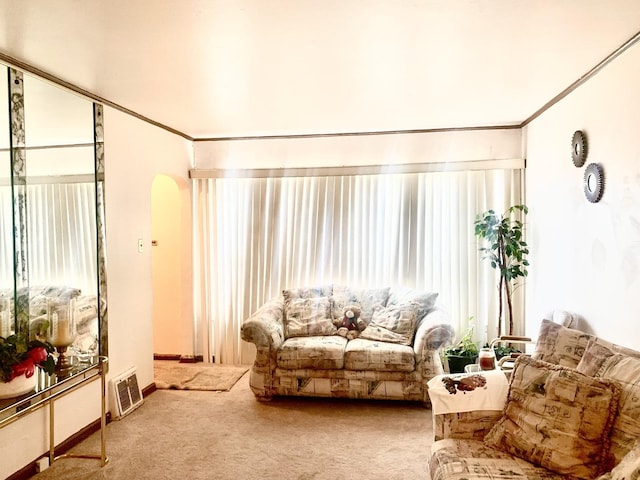 living area with arched walkways, carpet flooring, and crown molding