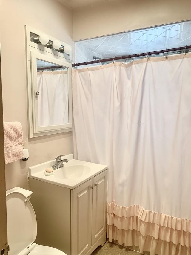 bathroom with toilet, curtained shower, and vanity