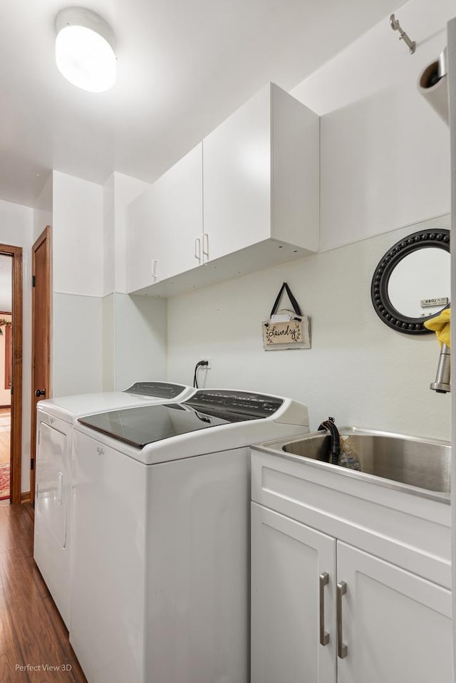 laundry area featuring a sink, dark wood-style floors, cabinet space, and washer and dryer