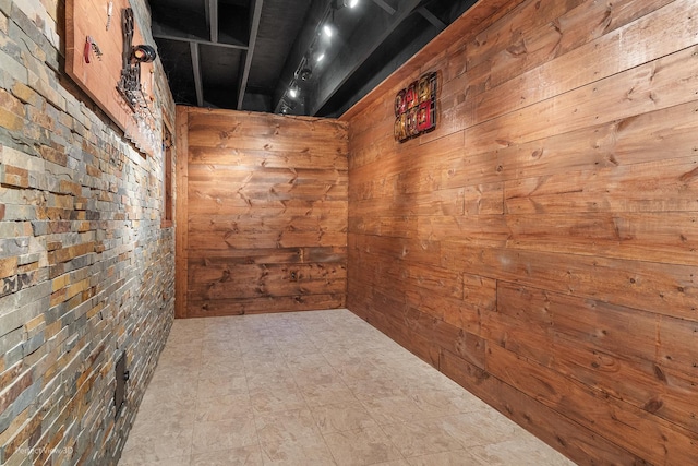 spare room featuring wood walls and brick wall