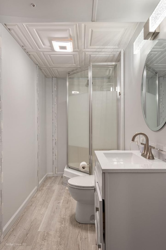 full bath featuring a stall shower, baseboards, toilet, wood finished floors, and vanity