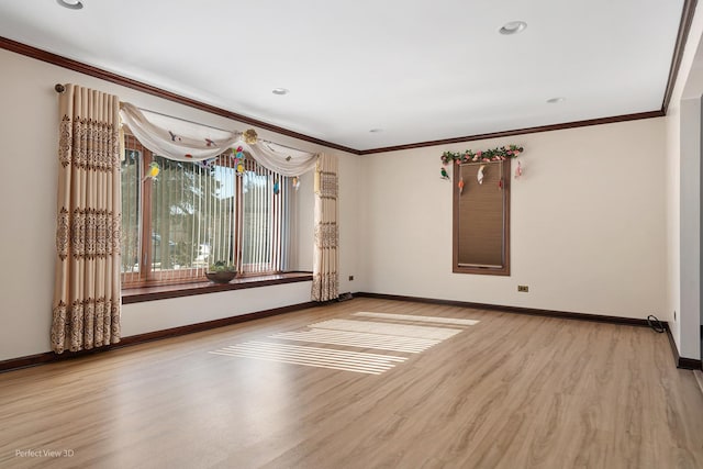 spare room featuring baseboards, ornamental molding, and wood finished floors