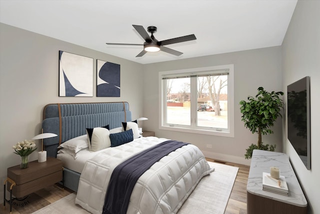 bedroom with a ceiling fan, visible vents, light wood-style flooring, and baseboards