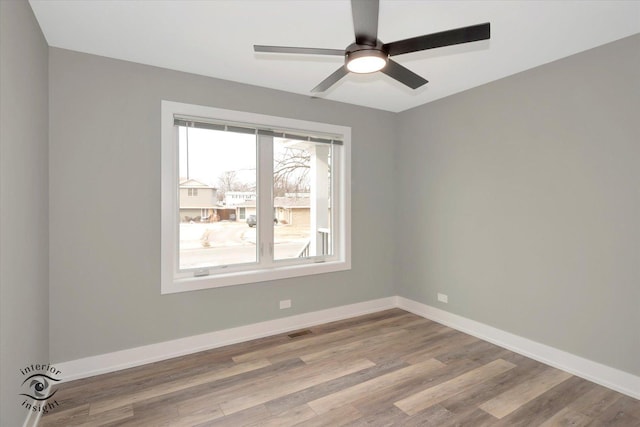 spare room with light wood-type flooring, visible vents, baseboards, and a ceiling fan