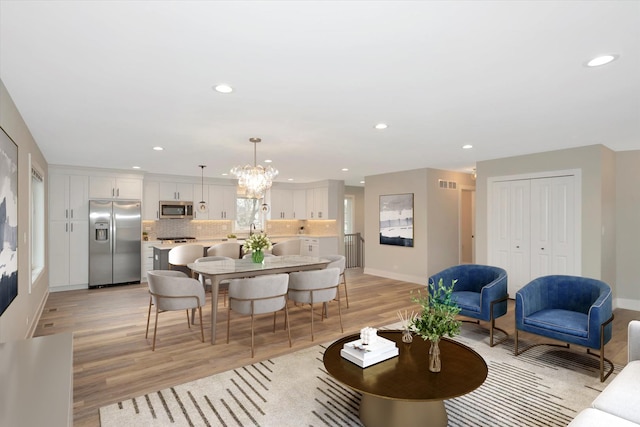 dining room featuring a notable chandelier, recessed lighting, visible vents, baseboards, and light wood-type flooring