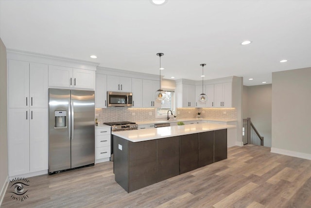 kitchen with hanging light fixtures, white cabinetry, appliances with stainless steel finishes, and light countertops