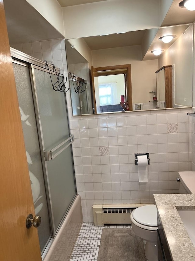 full bathroom featuring toilet, baseboard heating, tile walls, and vanity