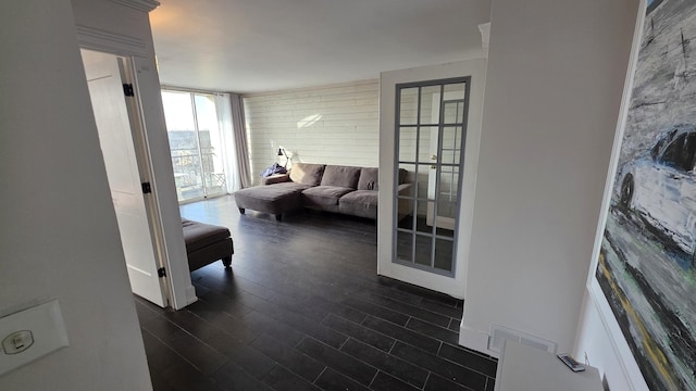 hallway featuring dark wood-style floors, a wall of windows, and visible vents