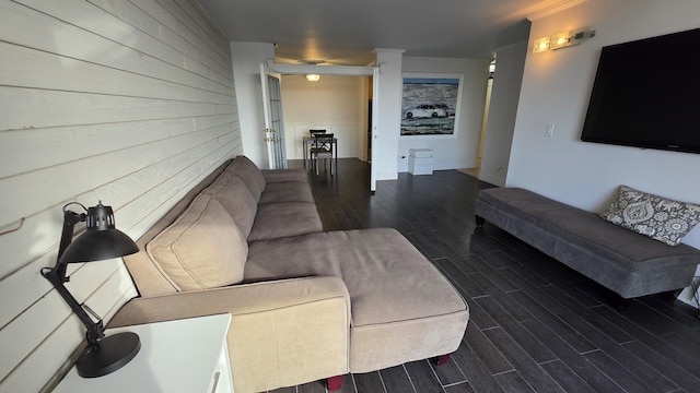 living area with wood tiled floor, wood walls, and decorative columns