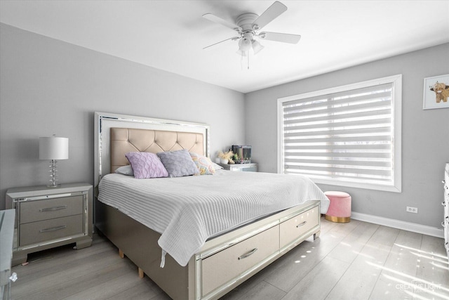 bedroom featuring light wood finished floors, baseboards, and a ceiling fan