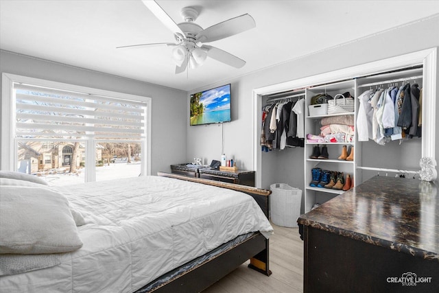 bedroom with ceiling fan, a closet, and light wood-type flooring