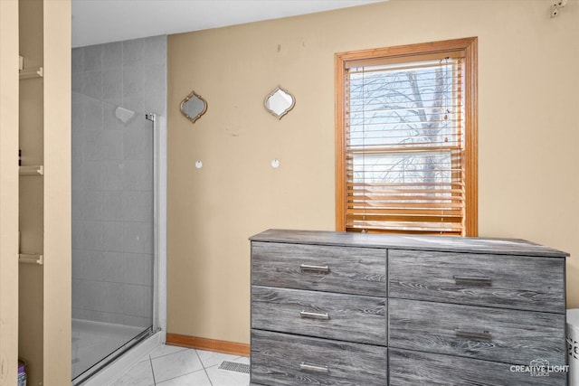 full bathroom with a stall shower, baseboards, and tile patterned floors