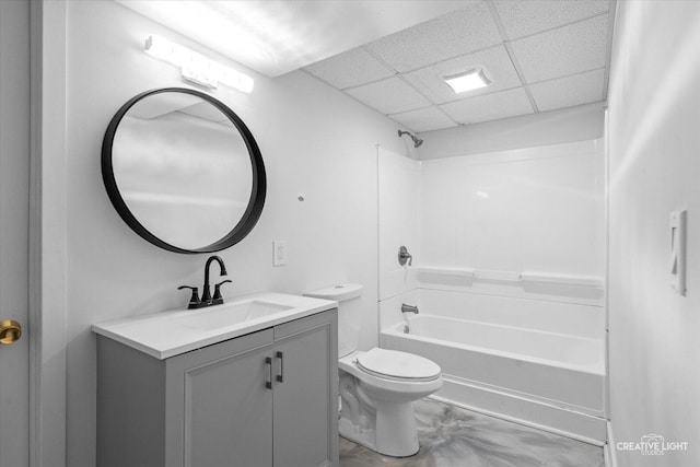 bathroom with toilet, vanity, a drop ceiling, and shower / bathtub combination