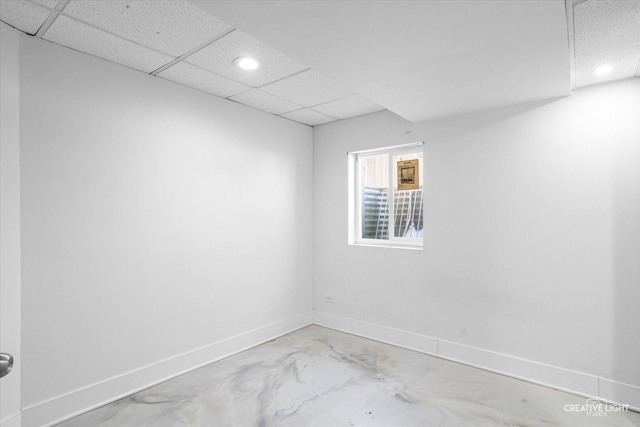 empty room featuring recessed lighting, a drop ceiling, and baseboards