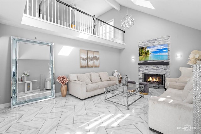 living room with a warm lit fireplace, a skylight, beam ceiling, high vaulted ceiling, and a notable chandelier