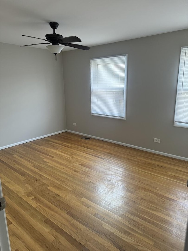 empty room featuring light wood-style floors, a healthy amount of sunlight, and baseboards