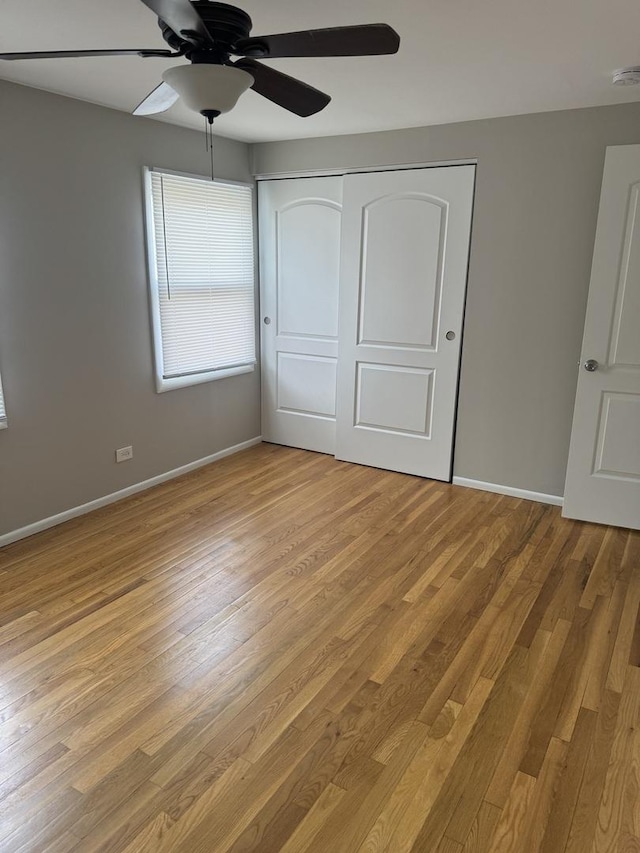 unfurnished bedroom with light wood finished floors, a ceiling fan, baseboards, and a closet