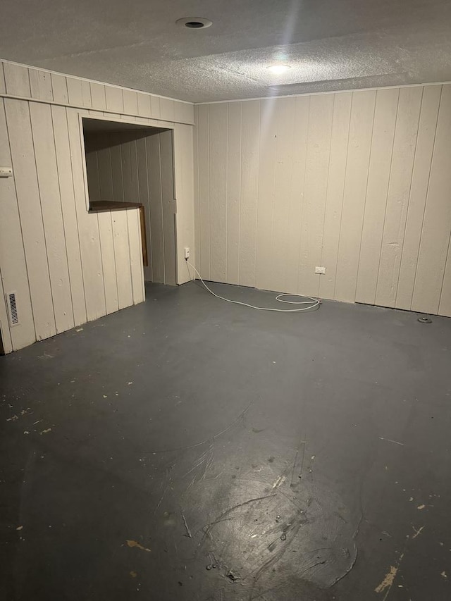 empty room with a textured ceiling and concrete flooring