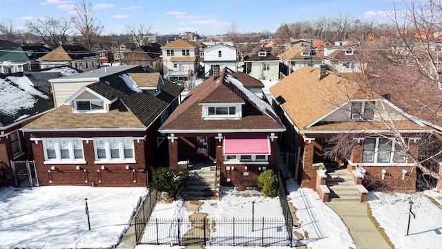 view of front of property with a residential view, brick siding, and fence