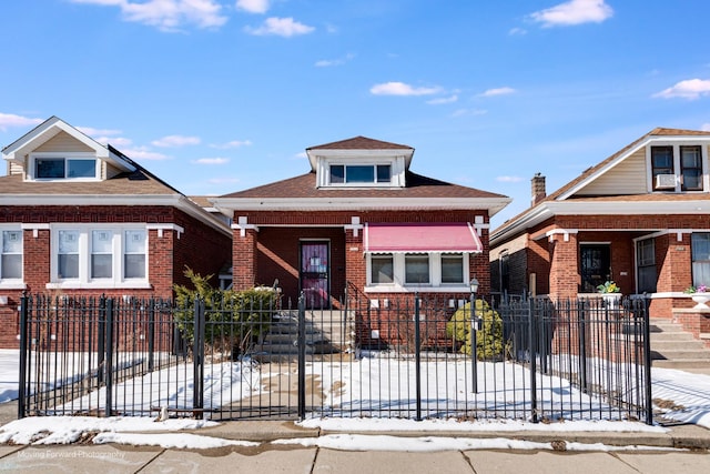 view of front facade with brick siding and a fenced front yard