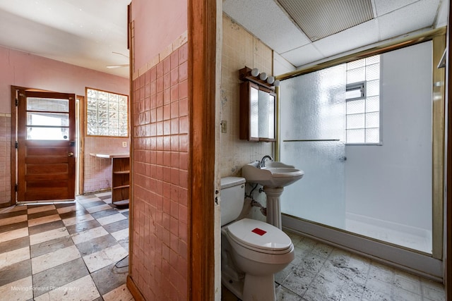 full bath with a healthy amount of sunlight, tile walls, and tile patterned floors