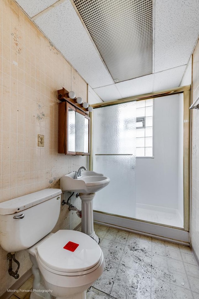 full bath featuring toilet, a walk in shower, a drop ceiling, and tile patterned floors