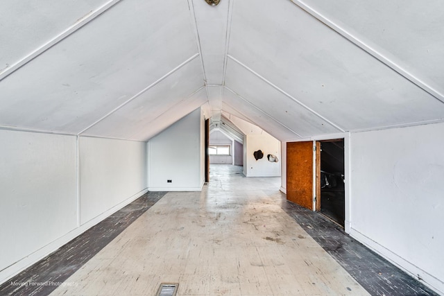 additional living space featuring lofted ceiling and visible vents