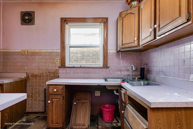 kitchen featuring brown cabinets, visible vents, light countertops, and a sink