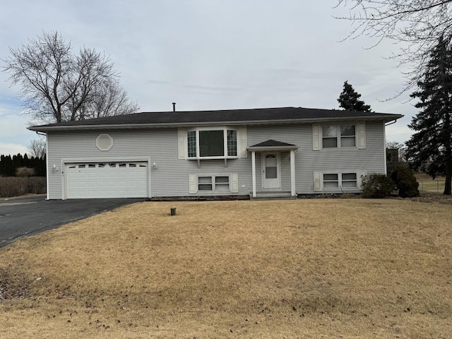 split foyer home with a garage, driveway, and a front lawn