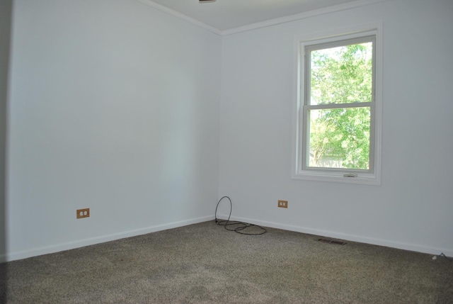 carpeted spare room with baseboards, visible vents, and crown molding