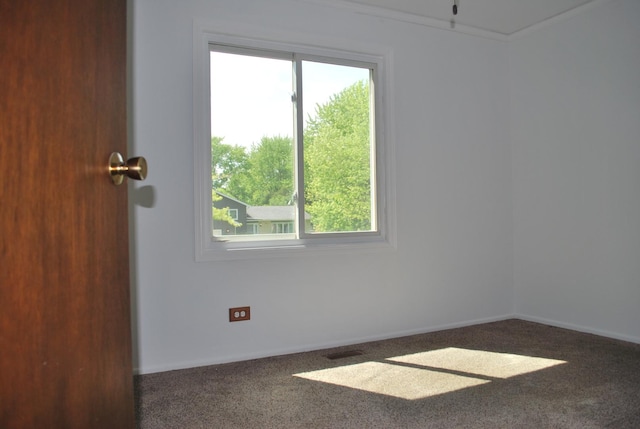 carpeted empty room featuring visible vents