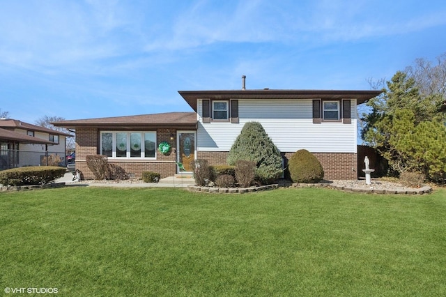 back of house featuring brick siding and a yard