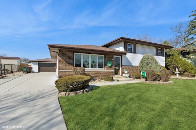 tri-level home featuring brick siding, a front yard, and fence