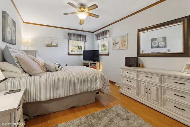 bedroom with crown molding, light wood-style flooring, baseboards, and ceiling fan