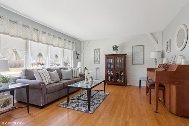 living area featuring baseboards and light wood finished floors