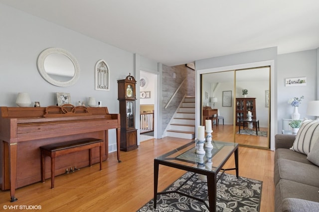 living room featuring light wood-type flooring and stairs