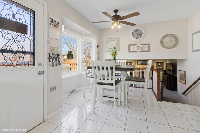 dining space with light tile patterned floors, baseboards, and a ceiling fan