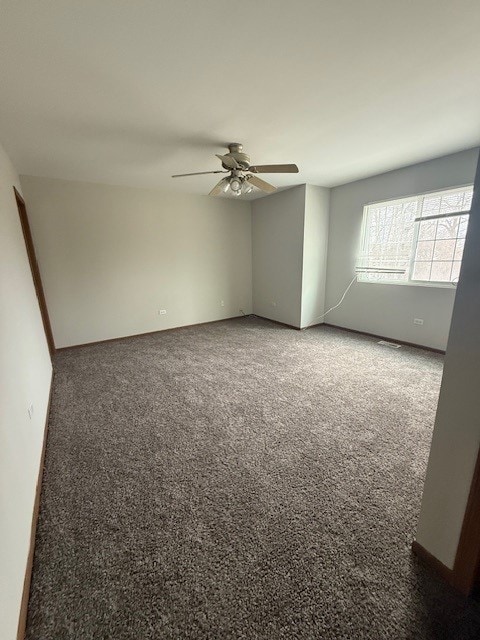 spare room with visible vents, carpet, and a ceiling fan