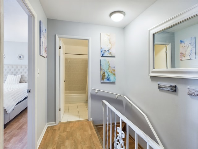 hall featuring light wood-type flooring and baseboards