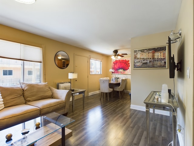 living area with dark wood-style floors, ceiling fan, and baseboards