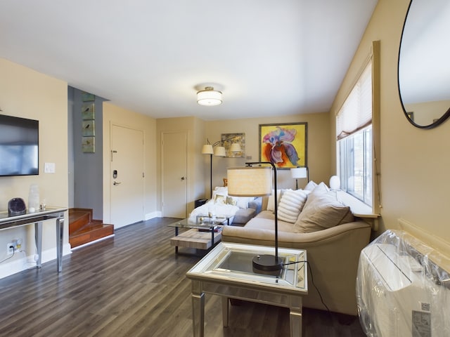 living area with baseboards, stairway, and dark wood-type flooring