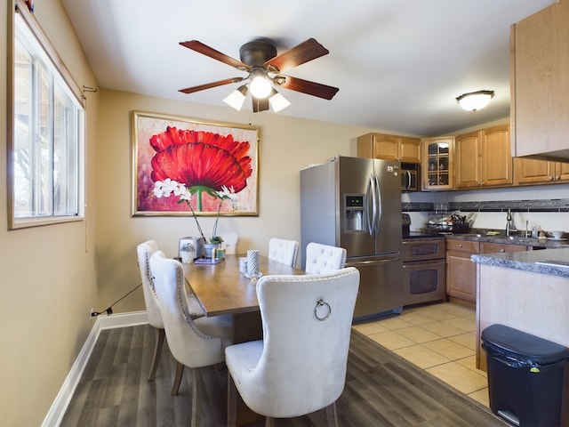 dining space with ceiling fan, light wood-style flooring, and baseboards