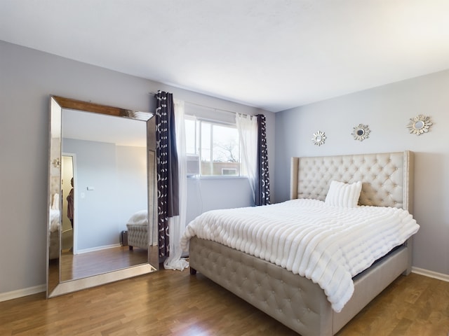 bedroom with wood finished floors and baseboards