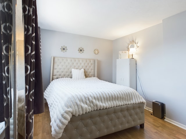 bedroom featuring baseboards and wood finished floors