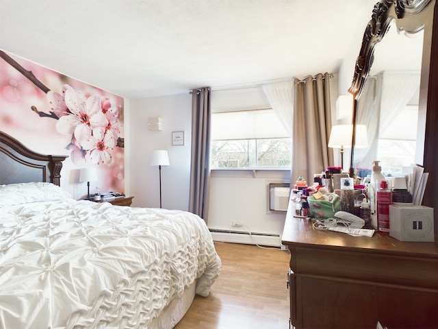 bedroom with light wood-type flooring and baseboard heating