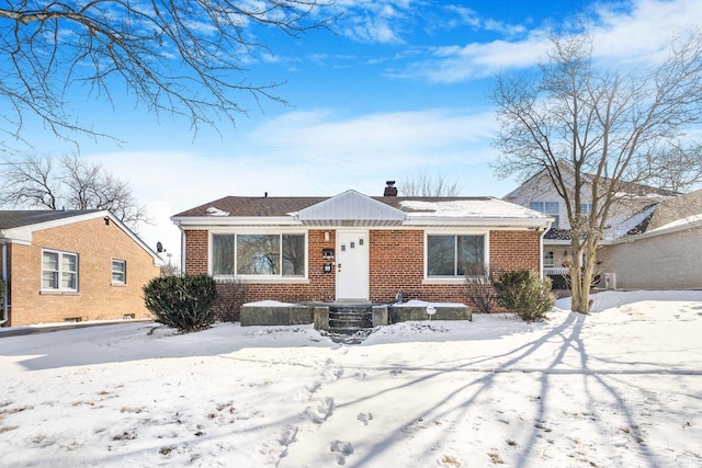 bungalow-style home with brick siding and a chimney