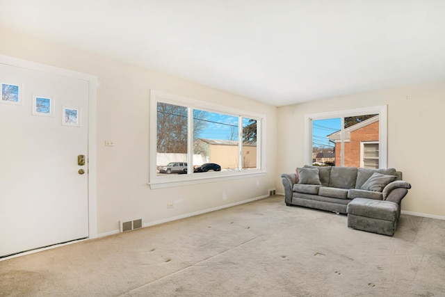 living room with visible vents, light carpet, and baseboards